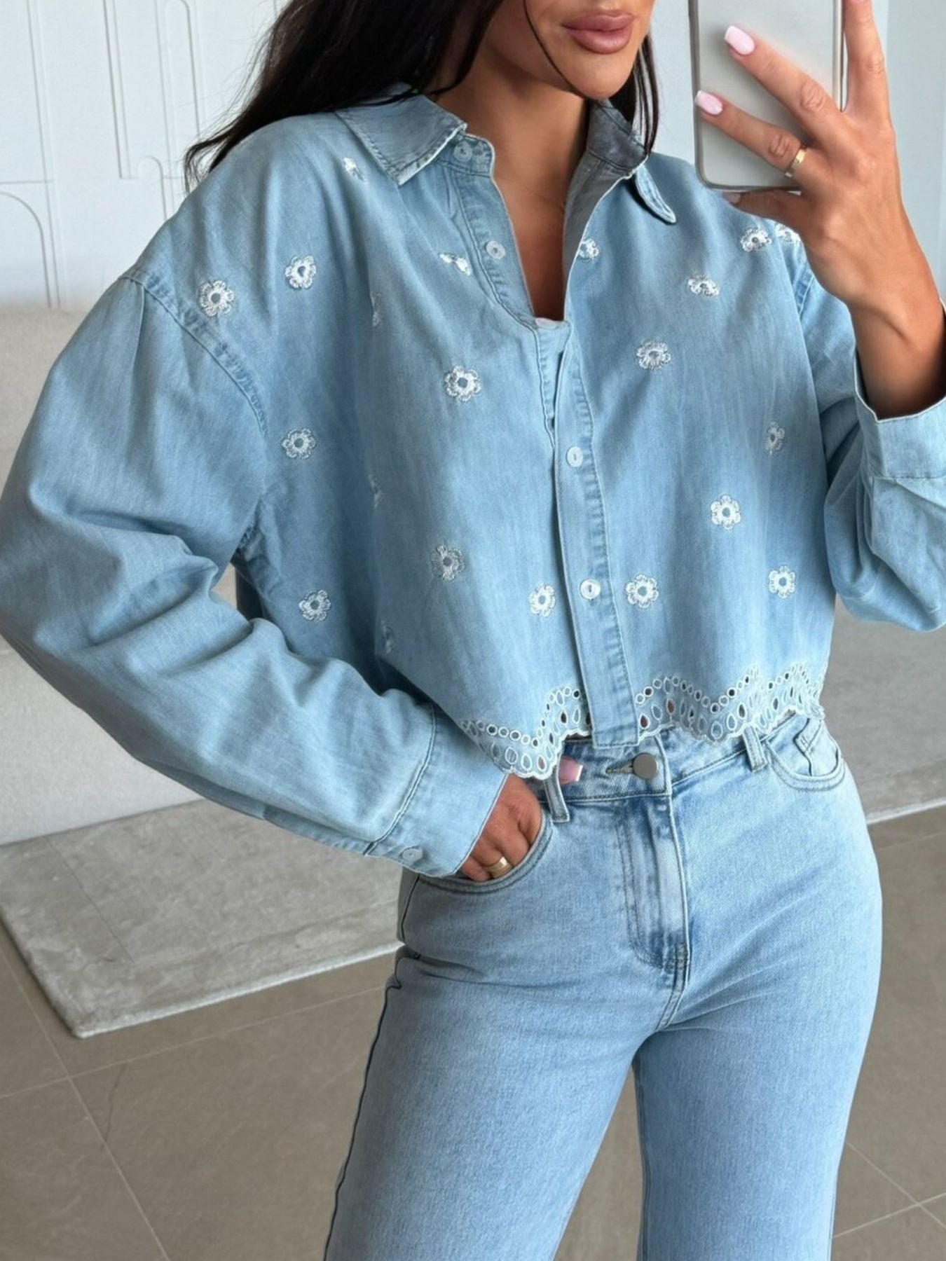 Light wash denim cropped shirt with white floral embroidery and eyelet hem detail