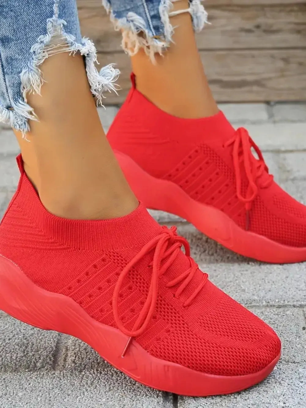 Red knit runner sneakers with sculpted sole and lace-up closure.