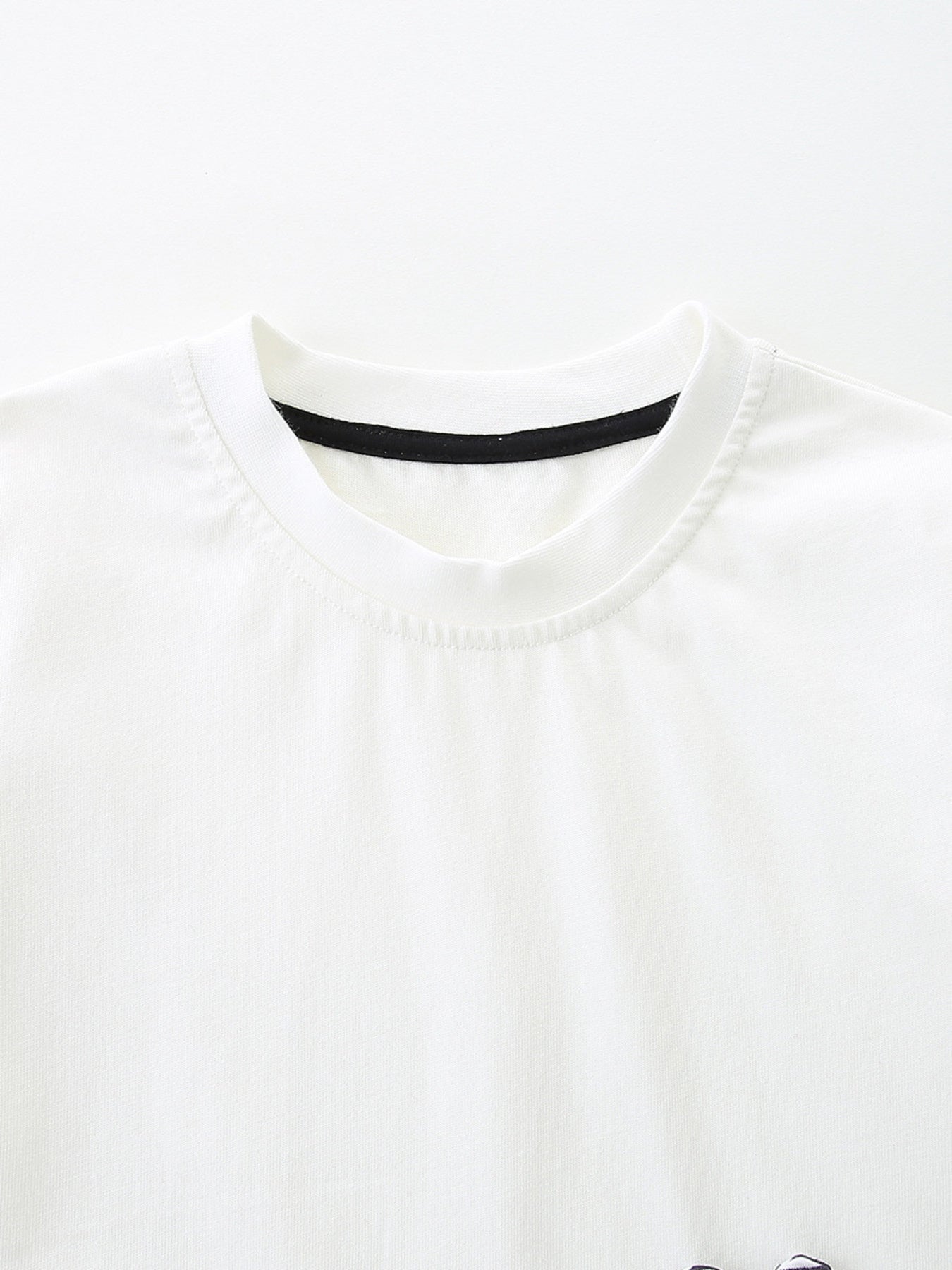 White cotton baby tee with black trim neckline, part of a zebra graphic set.