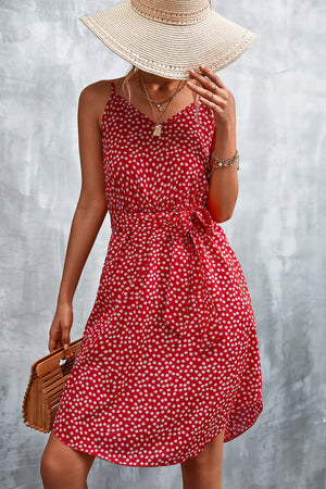 Red daisy print slip dress with tie waist, V-neck, and spaghetti straps.
