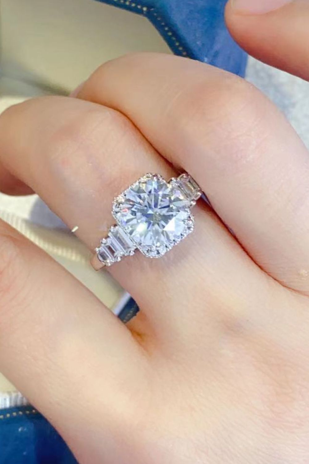 Silver ring with cushion cut moissanite and baguette accents.