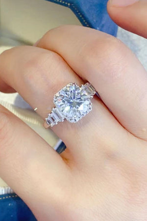 Silver ring with cushion cut moissanite and baguette accents.