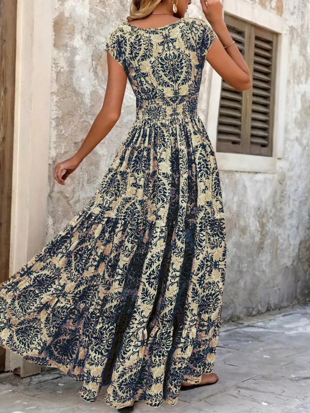 Maxi dress with smocked bodice and tiered skirt in a dark blue floral pattern.