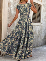 Maxi dress with smocked bodice and tiered skirt in a dark blue floral pattern.