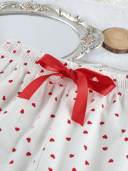 White cotton pajama shorts with red heart pattern and red bow detail