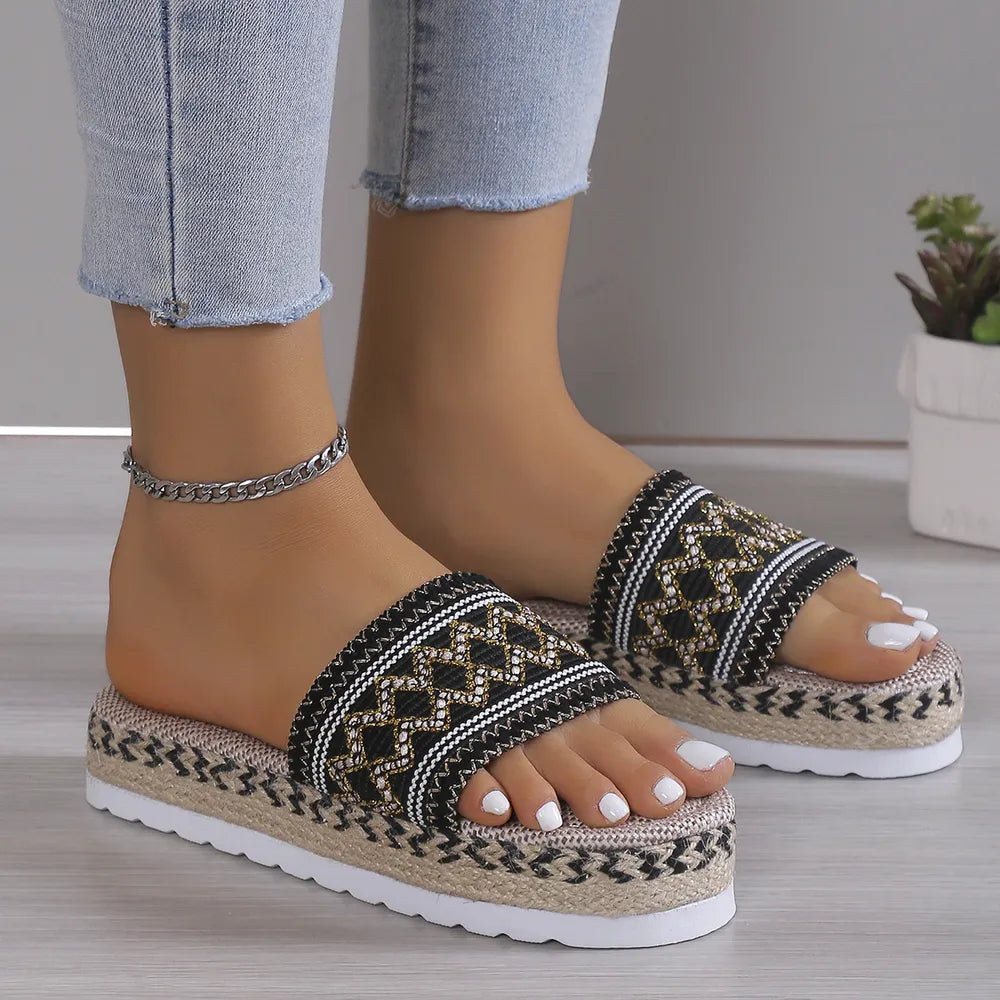 Embroidered espadrille platform slides with a multicolor geometric pattern and woven sole.