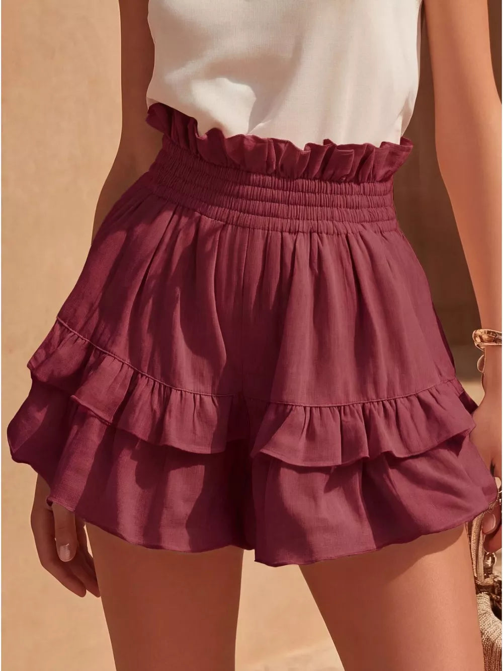 Red ruffled high-waisted shorts with smocked waistband and tiered hem.