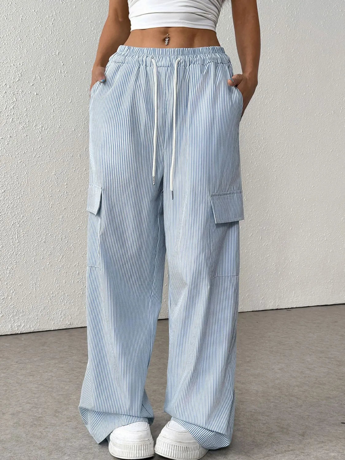 Light blue pleated cargo palazzo trousers with drawstring waist and side pockets.