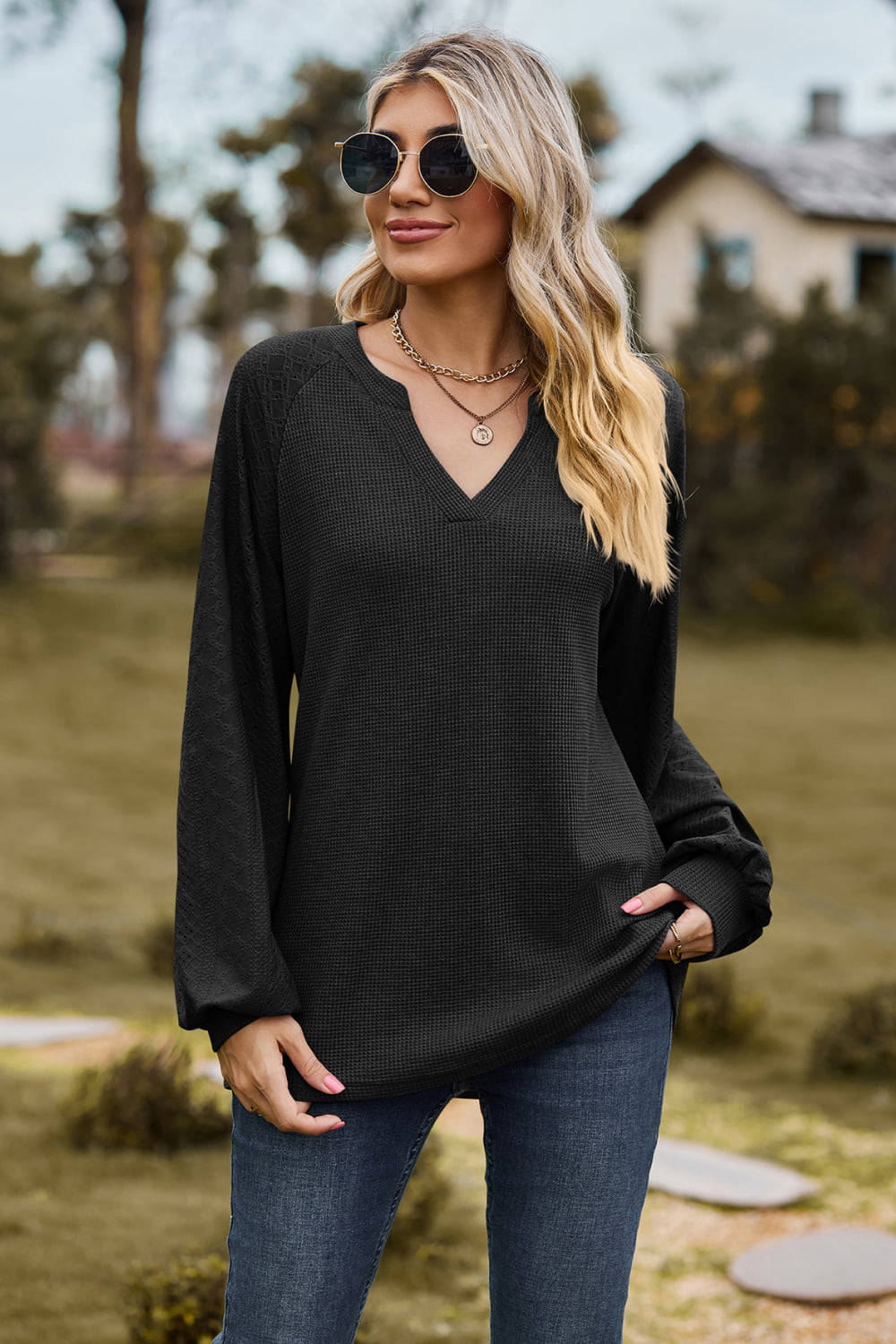 Black waffle knit raglan sweater with laser cut sleeves and v-neck