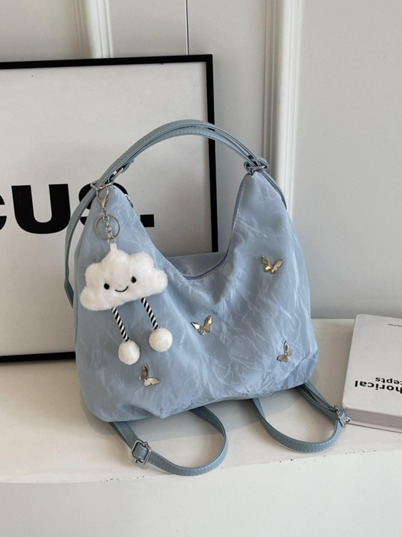 Light blue convertible shoulder bag with butterfly appliques and cloud charm