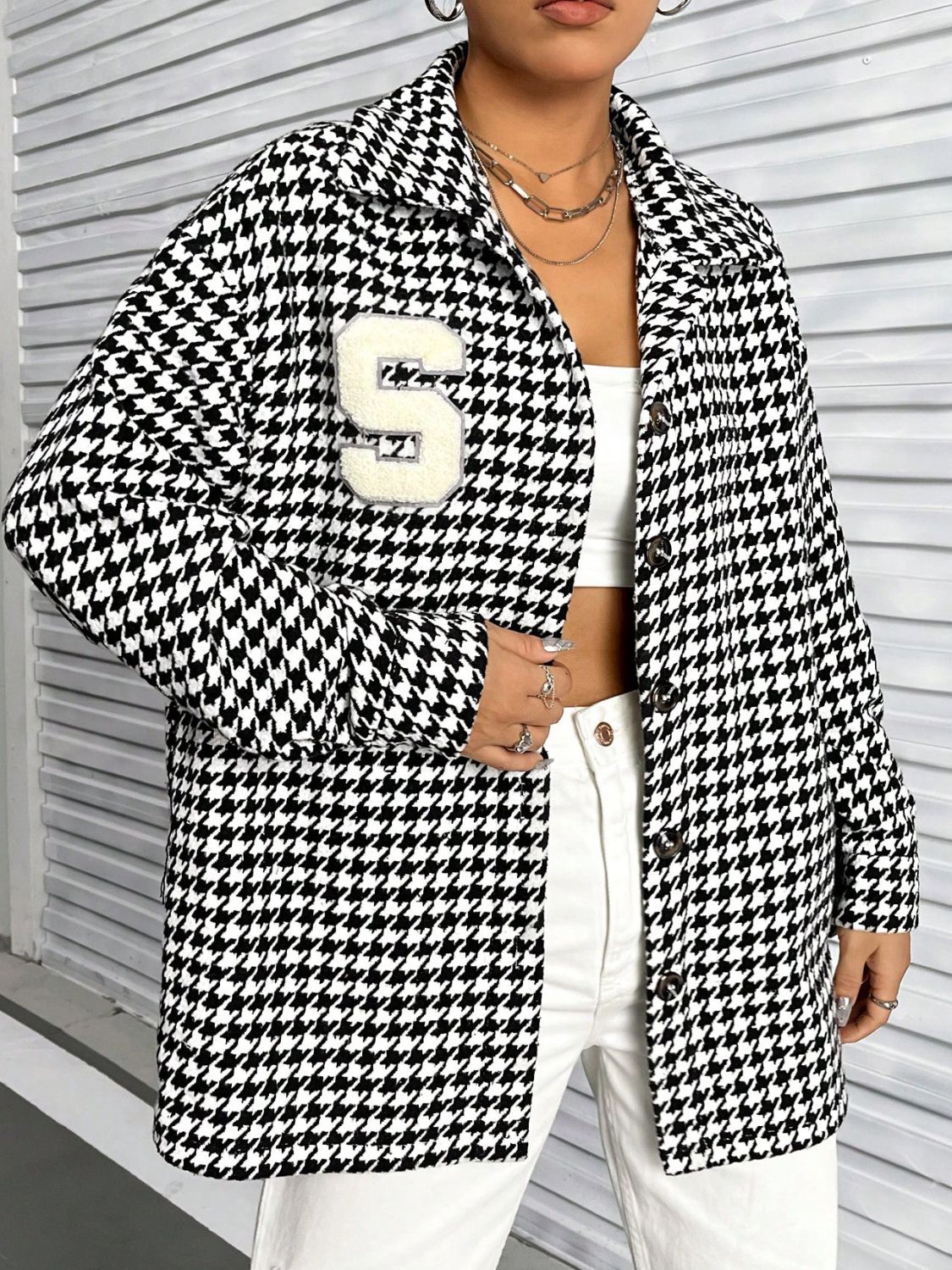 Houndstooth varsity overshirt in black with a white chenille S patch and button front.