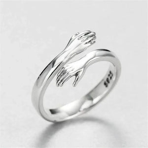 Hugging hands sterling silver ring with adjustable fit and affection design.