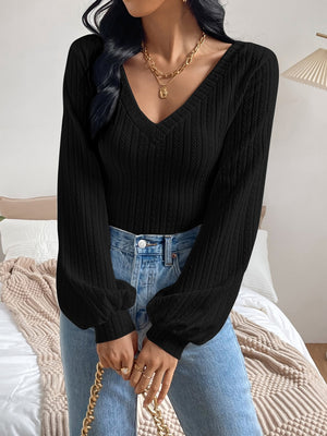 Black blouson top with textured chevron pattern, V-neck, and balloon sleeves.