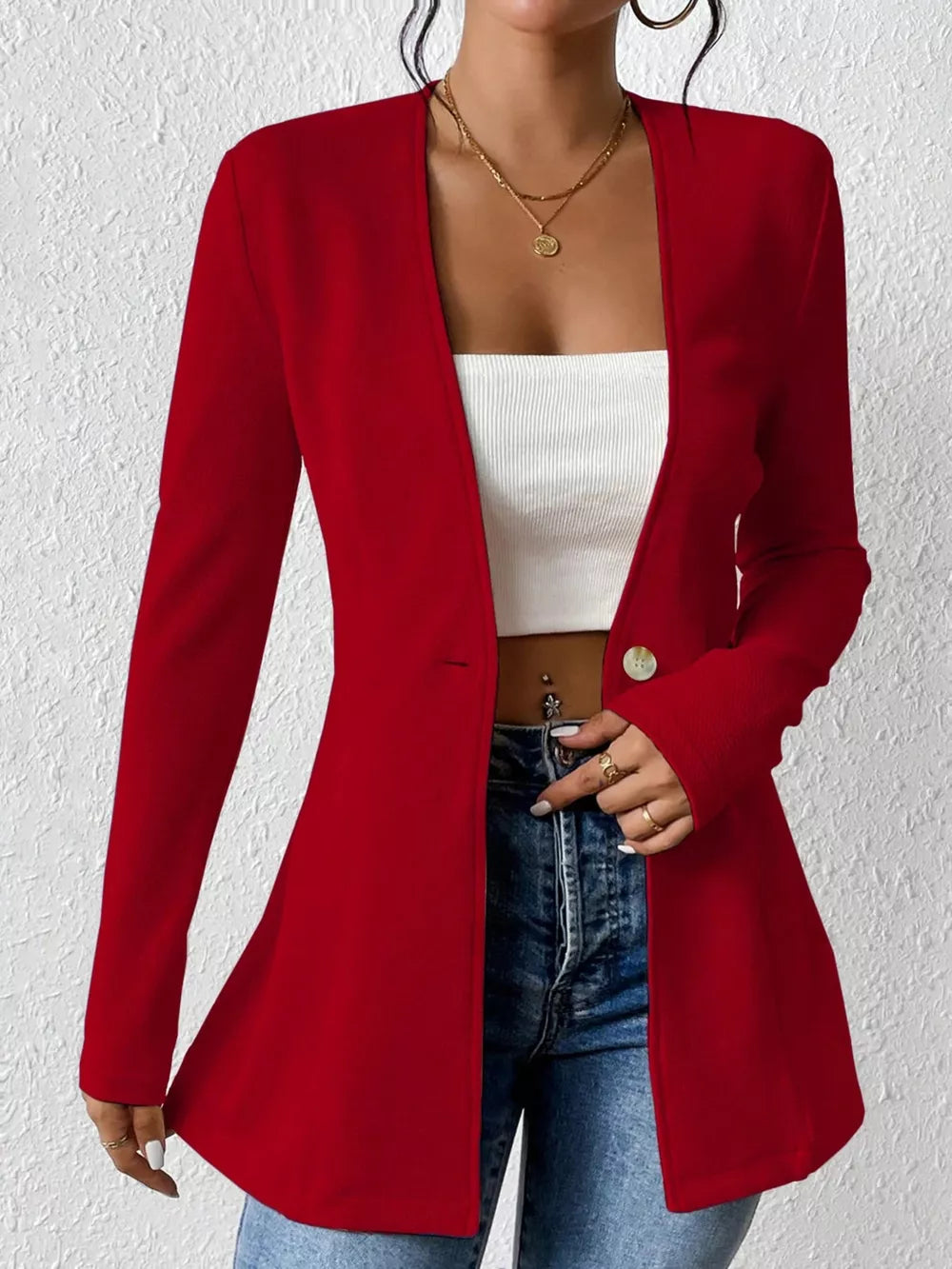 Red single-button blazer with tailored fit and long sleeves, styled open over a white top.