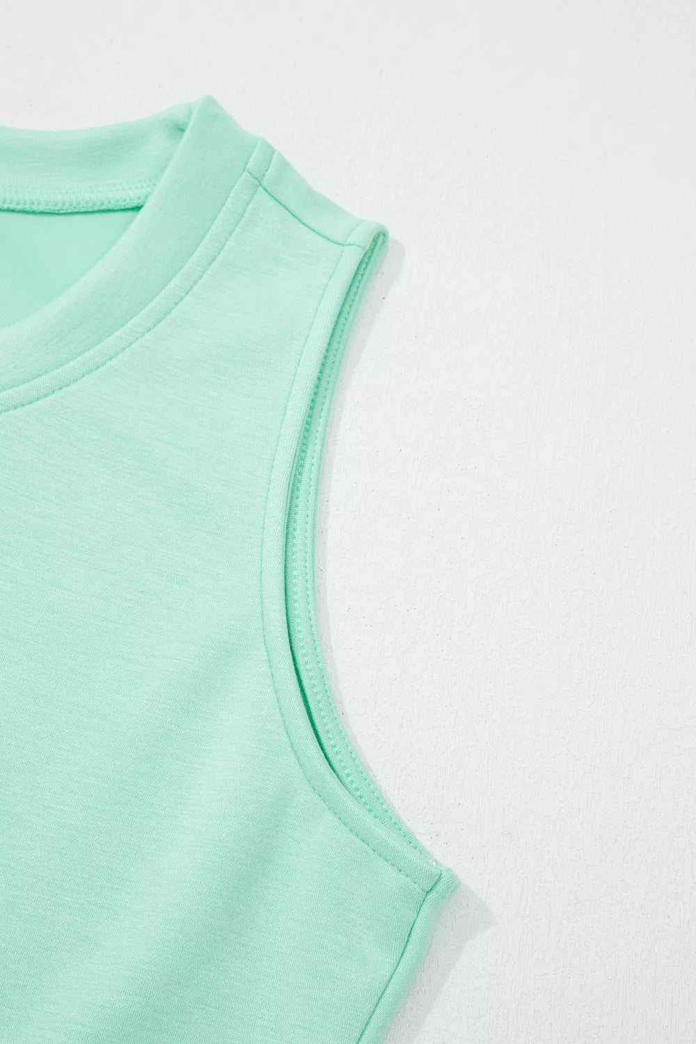 Mint green tank top with crew neck and contrast stitching detail.