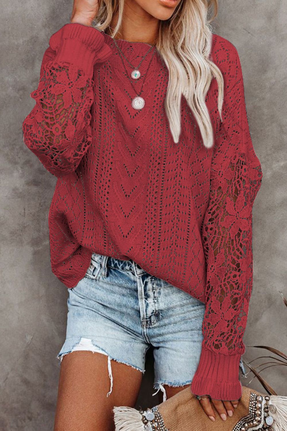 Red openwork knit sweater with lace sleeves and a chevron pattern.