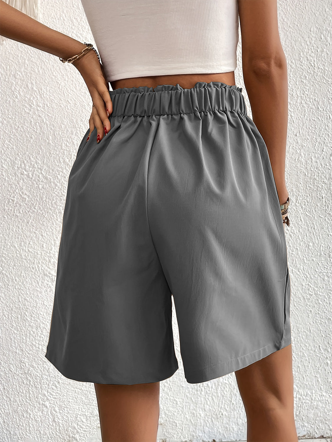 Pleated front bermuda shorts in dark gray with elastic waistband and side pockets.