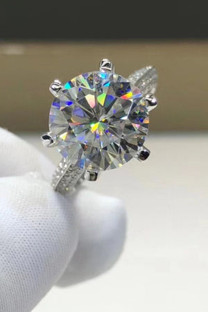Silver pavé band moissanite solitaire ring with a large, round-cut center stone.