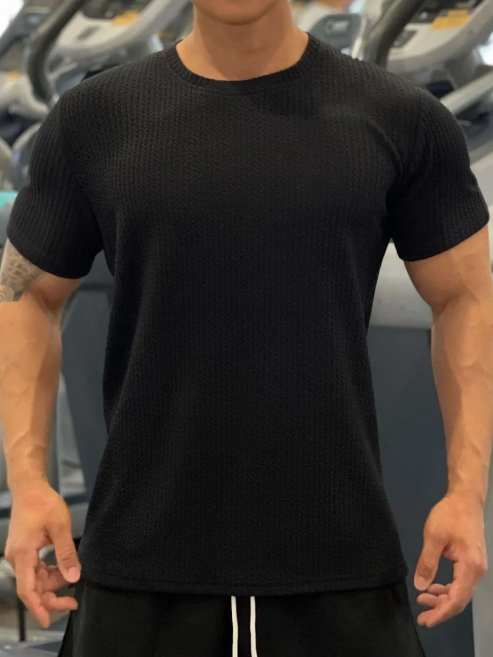 Black textured performance crew neck tee with short sleeves.