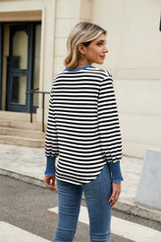 Striped long sleeve blouse with blue neckline and ruched cuffs.