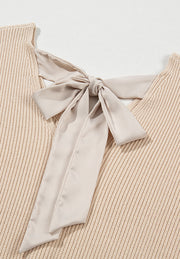 Beige ribbed knit sweater with a satin bow detail at the back neckline.