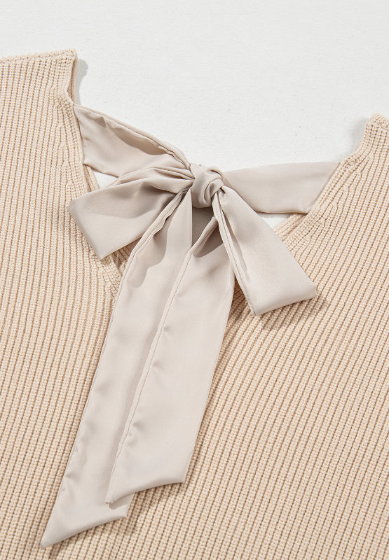 Beige ribbed knit sweater with a satin bow detail at the back neckline.