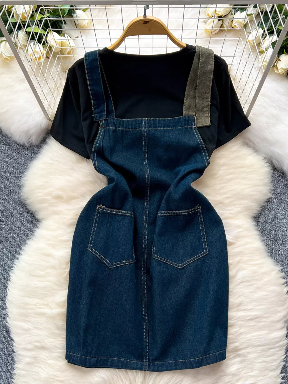 Black cotton tee with a blue denim overall dress featuring patch pockets and distressed details.
