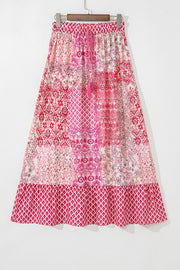 Printed tiered maxi skirt in dusty pink with tassel detail and boho pattern.