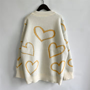 Cream acrylic knit sweater with yellow heart outline pattern and mock neck.