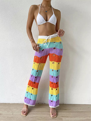 Vibrant crochet knit pants with rainbow stripes and cutouts, featuring a drawstring waist.