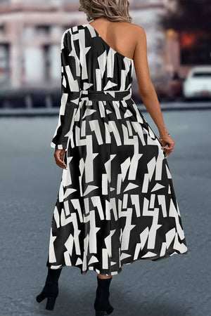 Black and white geometric print asymmetric maxi dress with belt and one long sleeve.