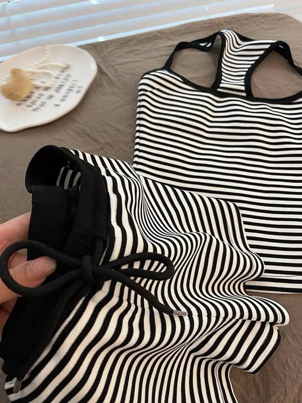 Black and white striped tank top and shorts set with drawstring detail.
