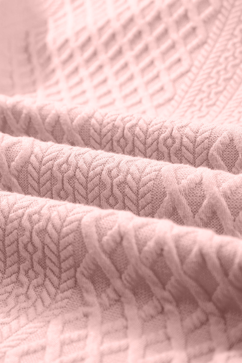 Blush pink textured trapeze dress fabric with a diamond and chevron pattern.