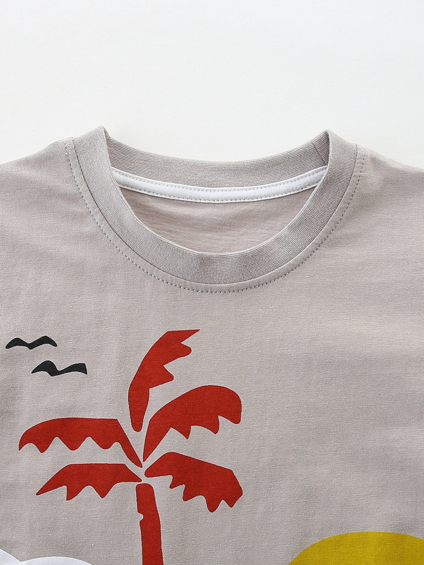 Kids grey cotton t-shirt with red palm tree and black birds graphic.