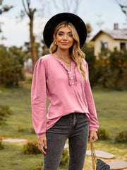 Pink ruffled henley blouse with button detail and long sleeves.