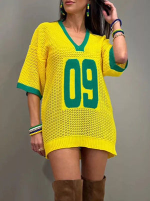 Yellow openwork knit tunic sweater with green trim and "09" graphic.