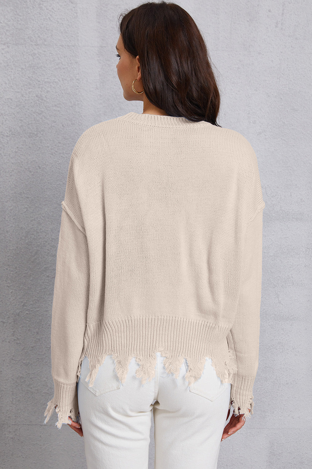 Apricot knit sweater with distressed hem and cuffs.