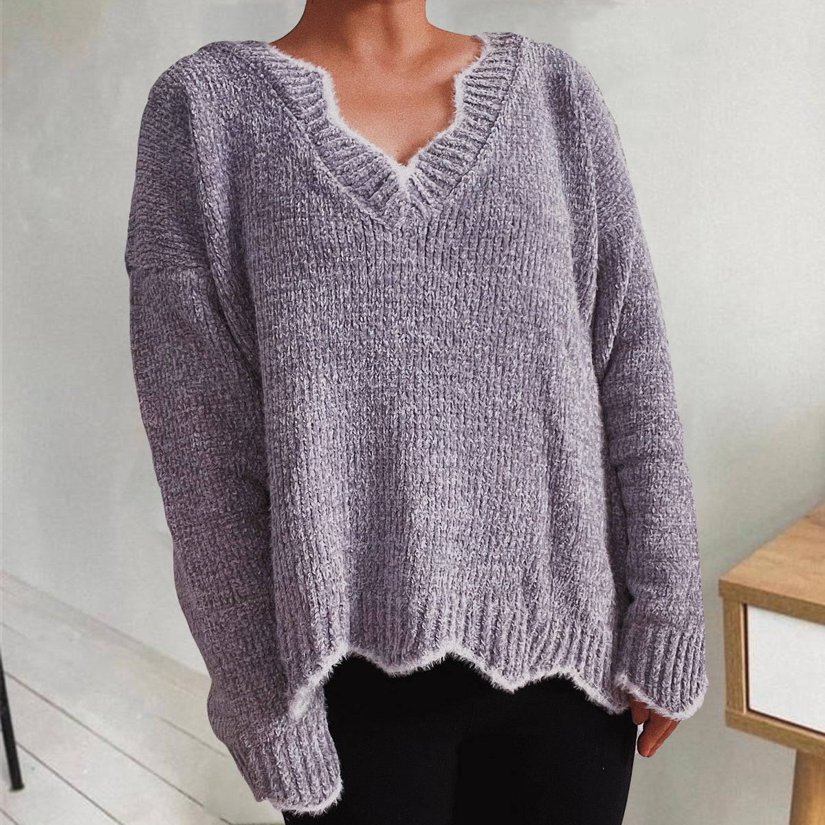 Lavender v-neck sweater with scalloped trim and ribbed knit texture.