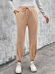 Beige tapered hem utility joggers with drawstring waist and patch pockets.