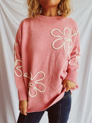 Watermelon pink knit sweater with outline floral pattern and crew neck.