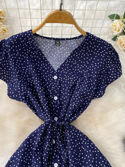 Dark Blue polka dot maxi dress with V-neck, button front, short sleeves, and tie belt.