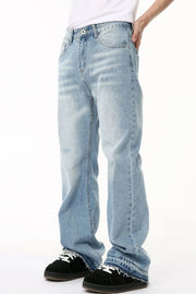 Baggy light wash denim jeans with distressed details and raw hem.