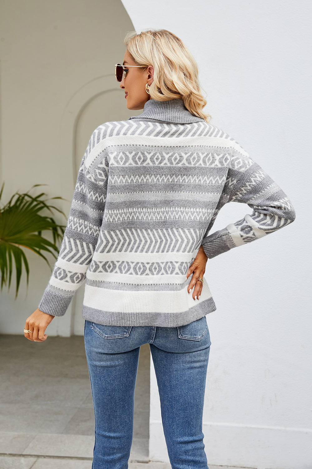 Light gray turtleneck sweater with geometric jacquard pattern and ribbed cuffs.