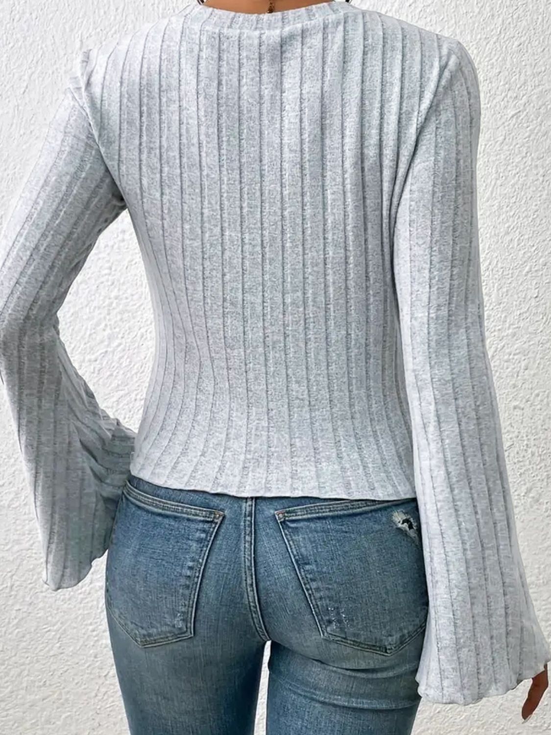 Gray ribbed knit top with flared sleeves and scalloped cuffs.
