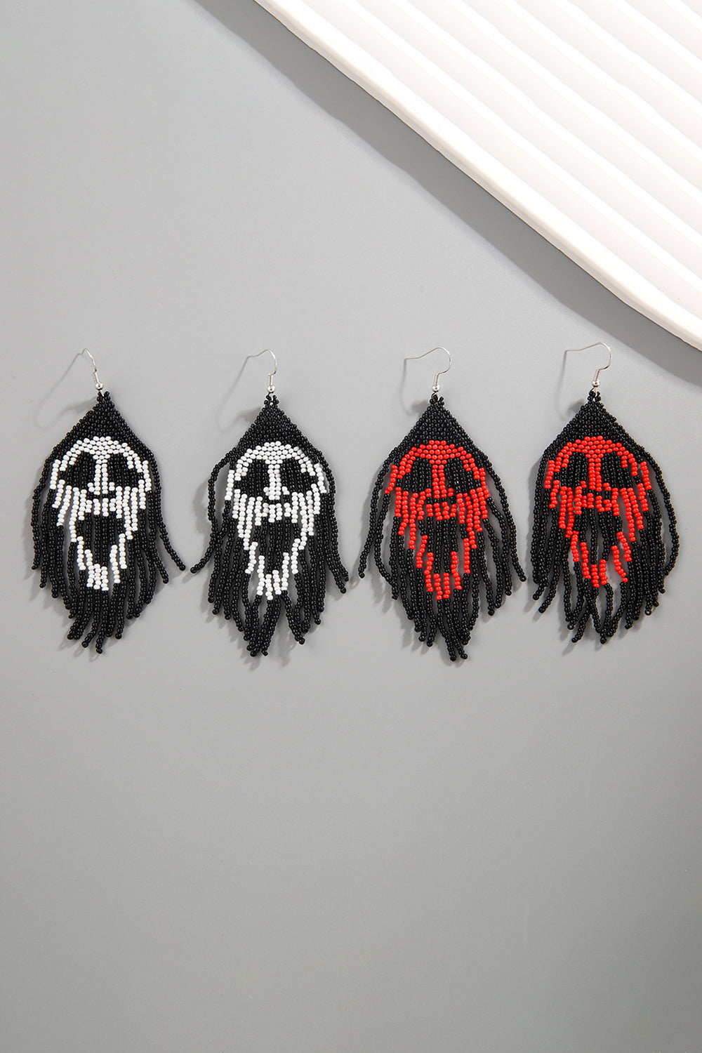 Beaded skull fringe earrings in black with white or red skull detail.
