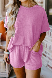 Pink waffle knit lounge set with short sleeves and elastic waist shorts.