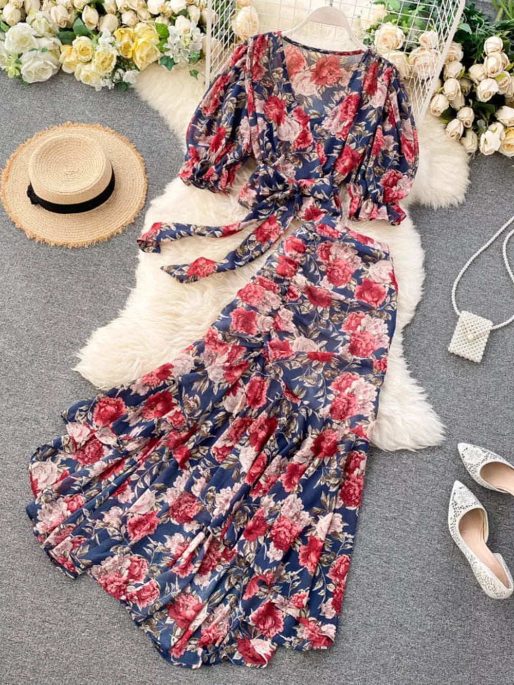 Chic floral two-piece crop set in dark blue with red and pink blooms, featuring a tie-front top and ruffled skirt.