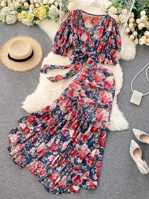 Chic floral two-piece crop set in dark blue with red and pink blooms, featuring a tie-front top and ruffled skirt.