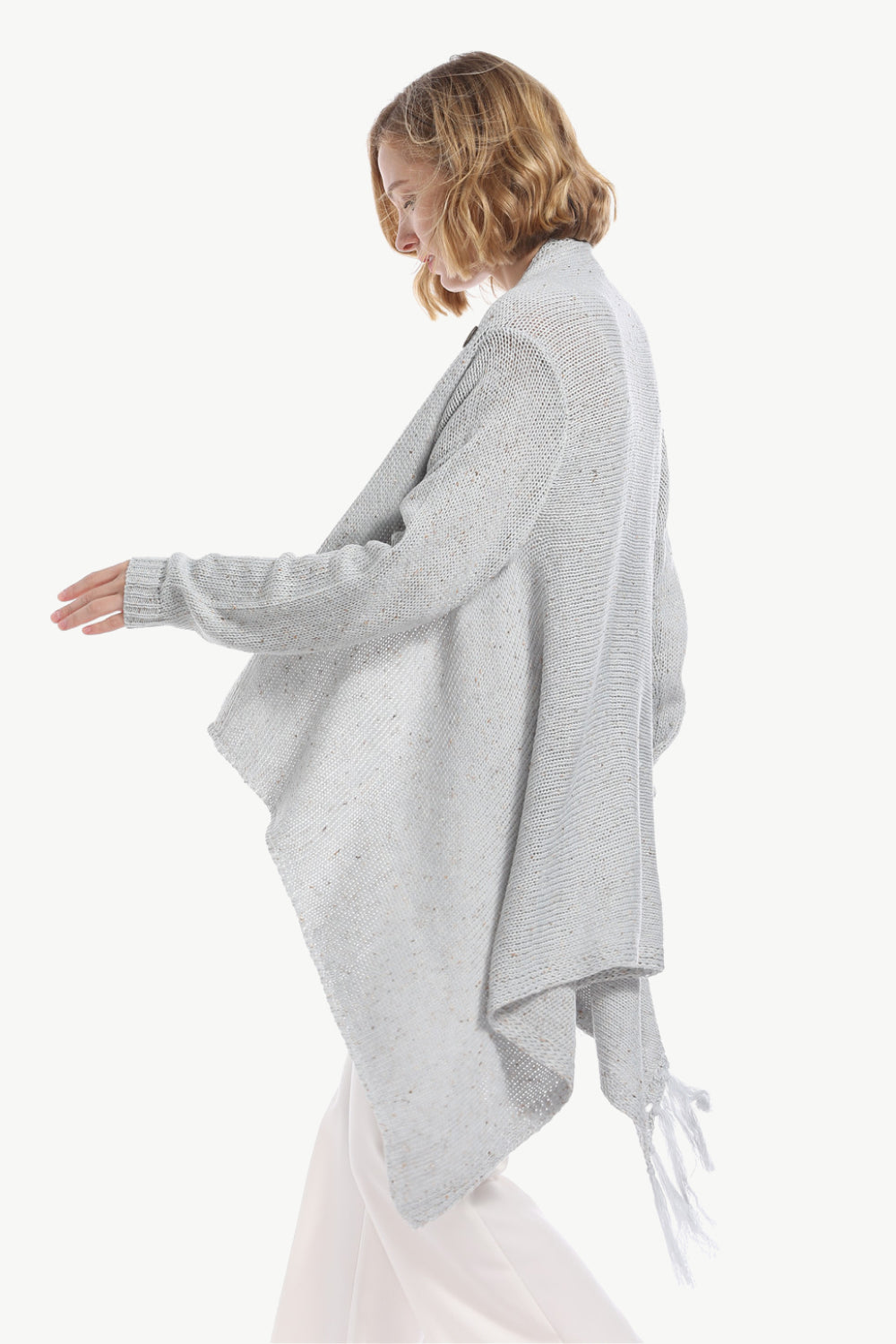 Asymmetric fringe knit cardigan in light gray with a waterfall hem and button closure.