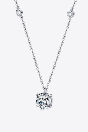 Silver solitaire necklace with a floating moissanite diamond and bezel-set accent stones.